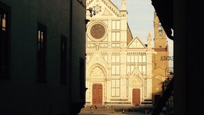 A church with a large circular window and a bell tower. - SantaCroce Junior Luxury Suite (Firenze)