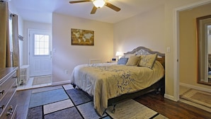A bedroom with a bed, a ceiling fan, a world map artwork, a nightstand, and a door. - ❤️ Perfect for traveling nurses! - Wifi, AC, 4-6 minute commute to Hershey Med (Hummelstown)