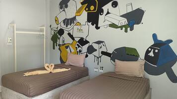 Quarto com duas camas, um mural na parede e um cabideiro.