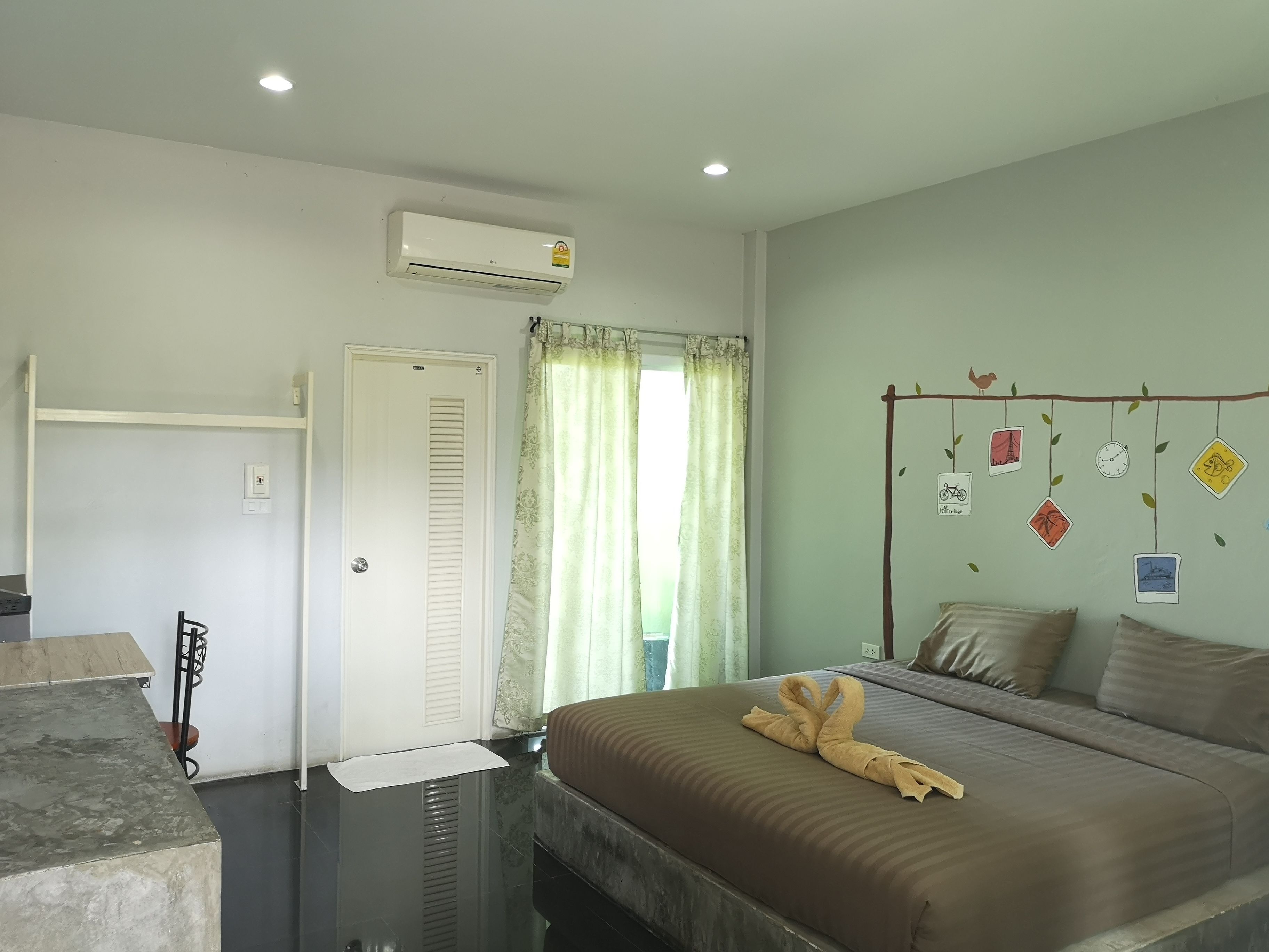 Habitación de hotel con cama, escritorio, aire acondicionado y ventana con cortinas.