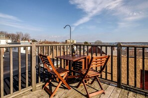 A wooden deck with a table and chairs, overlooking a body of water and buildings. - Panoramic Water, Island & City Views w/Private Roof Deck (Portland)