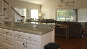 A spacious kitchen with a central island, white cabinetry, and a ceiling fan.