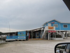 Un bâtiment bleu avec une enseigne indiquant « Billy’s Seafood » et « Écrevisses épicées ».