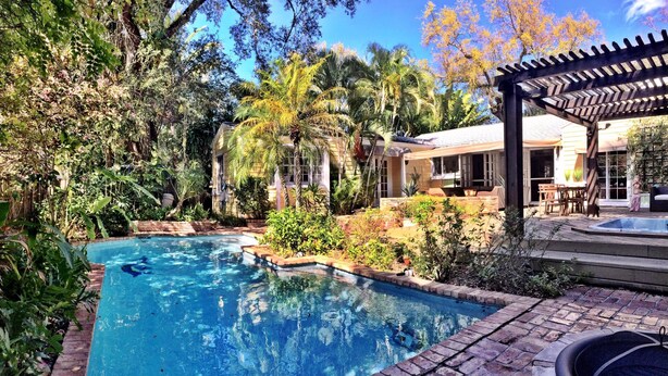 A swimming pool surrounded by lush vegetation and a covered patio area. - VOTED BEST FORT LAUDERDALE LOCATION! WALK TO SHOPS, RESTURAUNTS, & BEACH. (Ft Lauderdale)