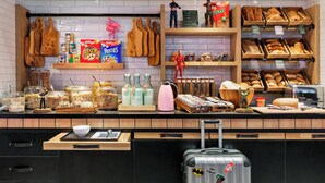 A breakfast buffet with various food items, condiments, and a Batman-themed suitcase.