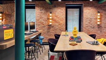 A modern meeting room with a brick wall, wooden table, and black chairs.