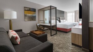 Una habitación de hotel con sofá, escritorio, cama y televisor.