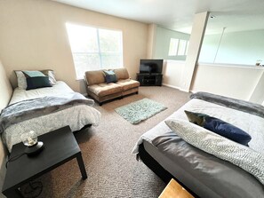 A room with two beds, a sofa, a TV, and a window. - NEW HOT TUB! POOL & grill! SeaWorld/Military (San Antonio)