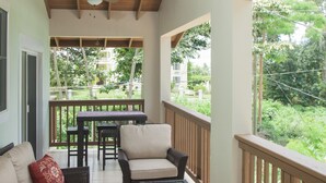 A covered outdoor seating area with wicker furniture, a ceiling fan, and a surfboard hanging from the ceiling. - Upscale, new, centrally located to all the attractions in Rincon w beach access (Rincon)