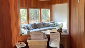 Una habitación con paneles de madera, un sofá, una araña y un cartel de bienvenida.
