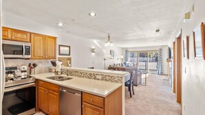 A modern kitchen with wooden cabinets, stainless steel appliances, and a large island.