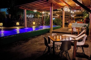 Eine Terrasse im Freien mit einer Steinmauer, einem Wasserspiel und Sitzgelegenheiten.