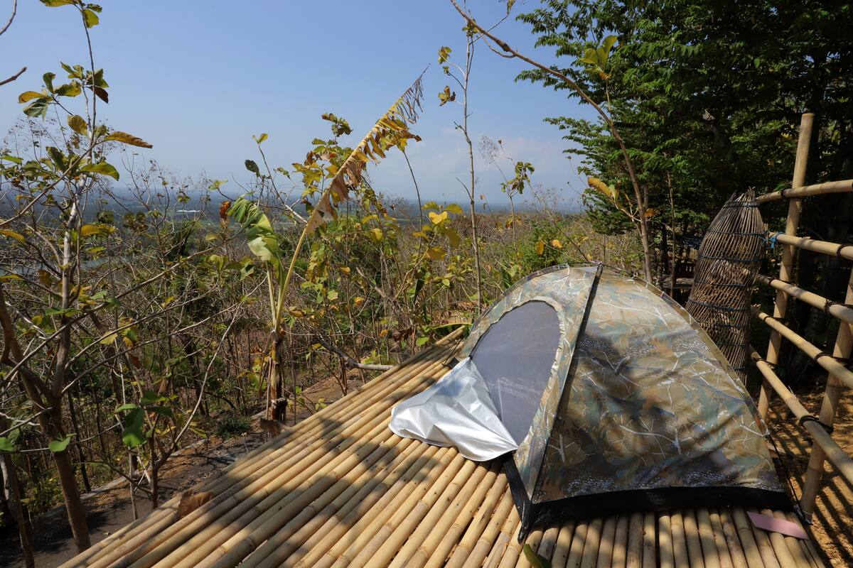 A bamboo structure with a camouflage tent.