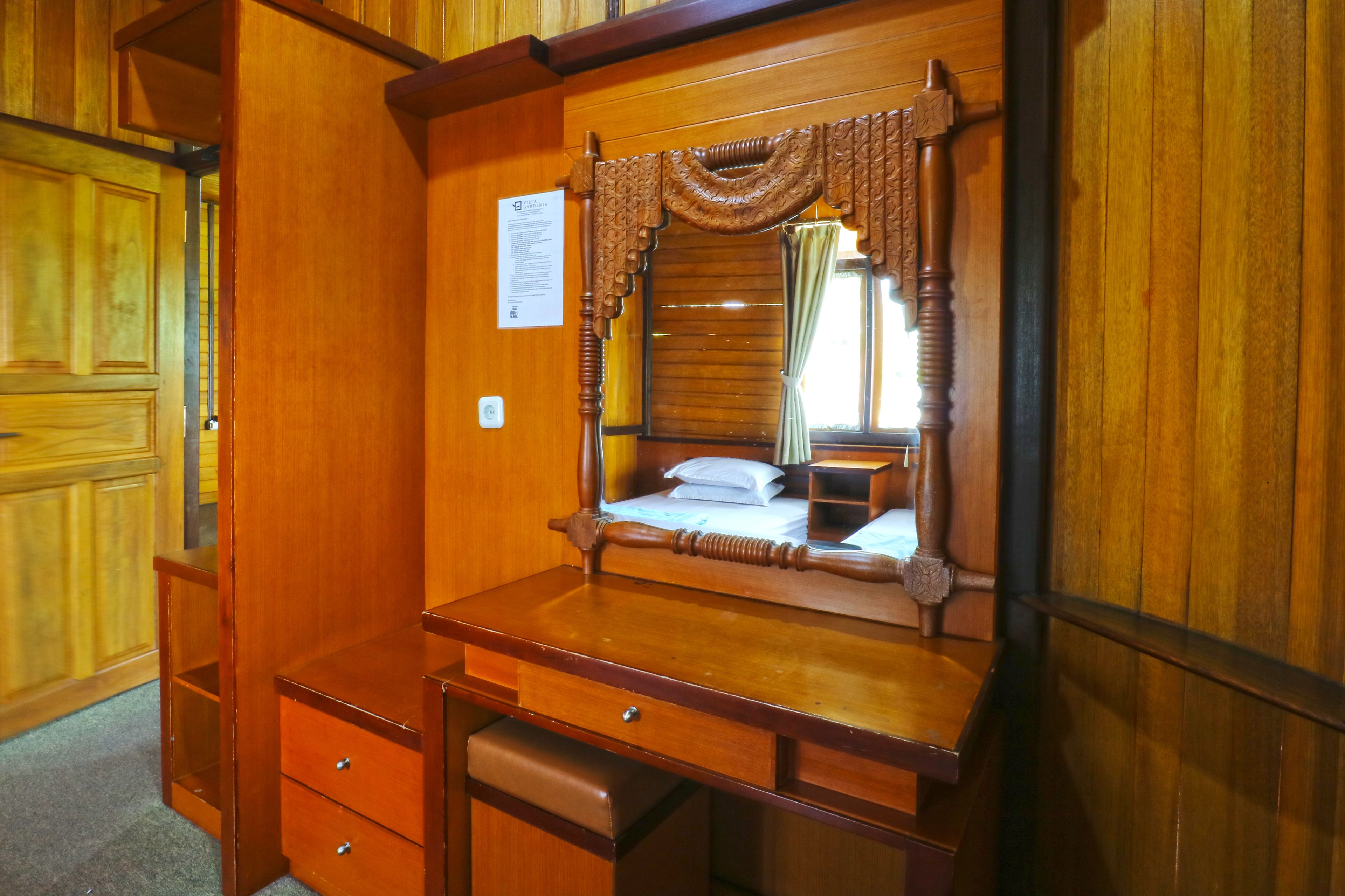 Una habitación de madera con una cama, un escritorio y una silla.
