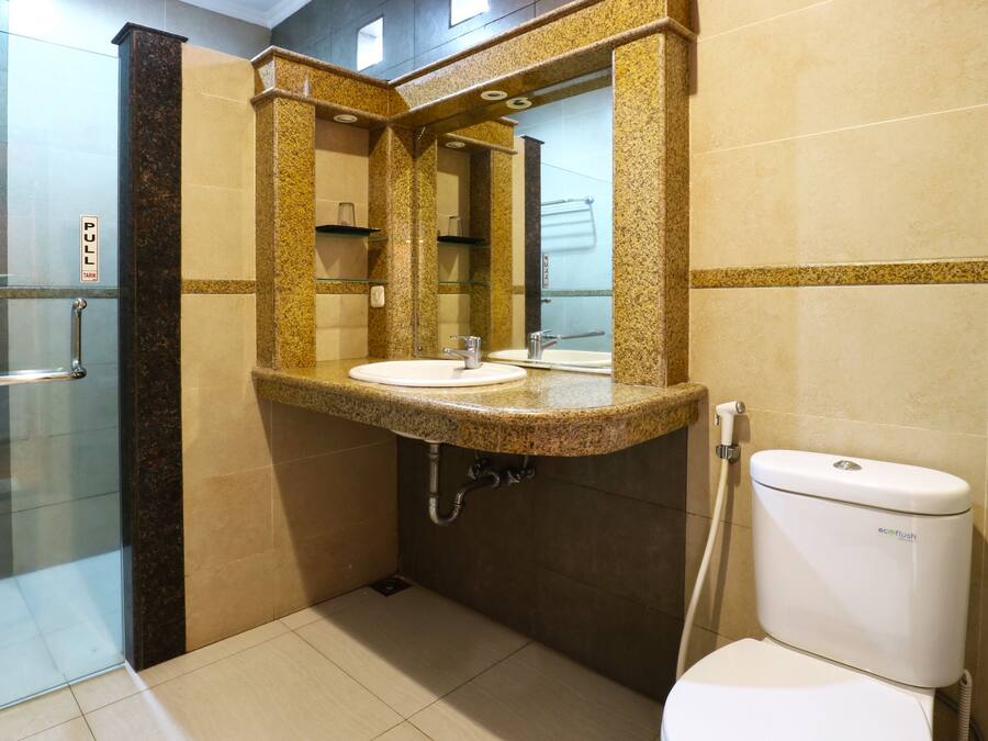 A bathroom with a sink, mirror, and toilet.