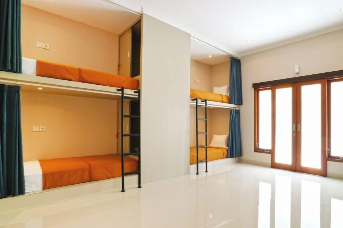 A room with bunk beds, a ladder, and a sliding door.
