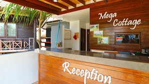 A reception desk with a wooden finish and a sign that reads "Reception." - Mega Cottages (Lembongan Island)