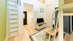 A modern apartment with a loft-style living area, a dining space, and a staircase. - Trip Pod Minoshima A (Fukuoka)