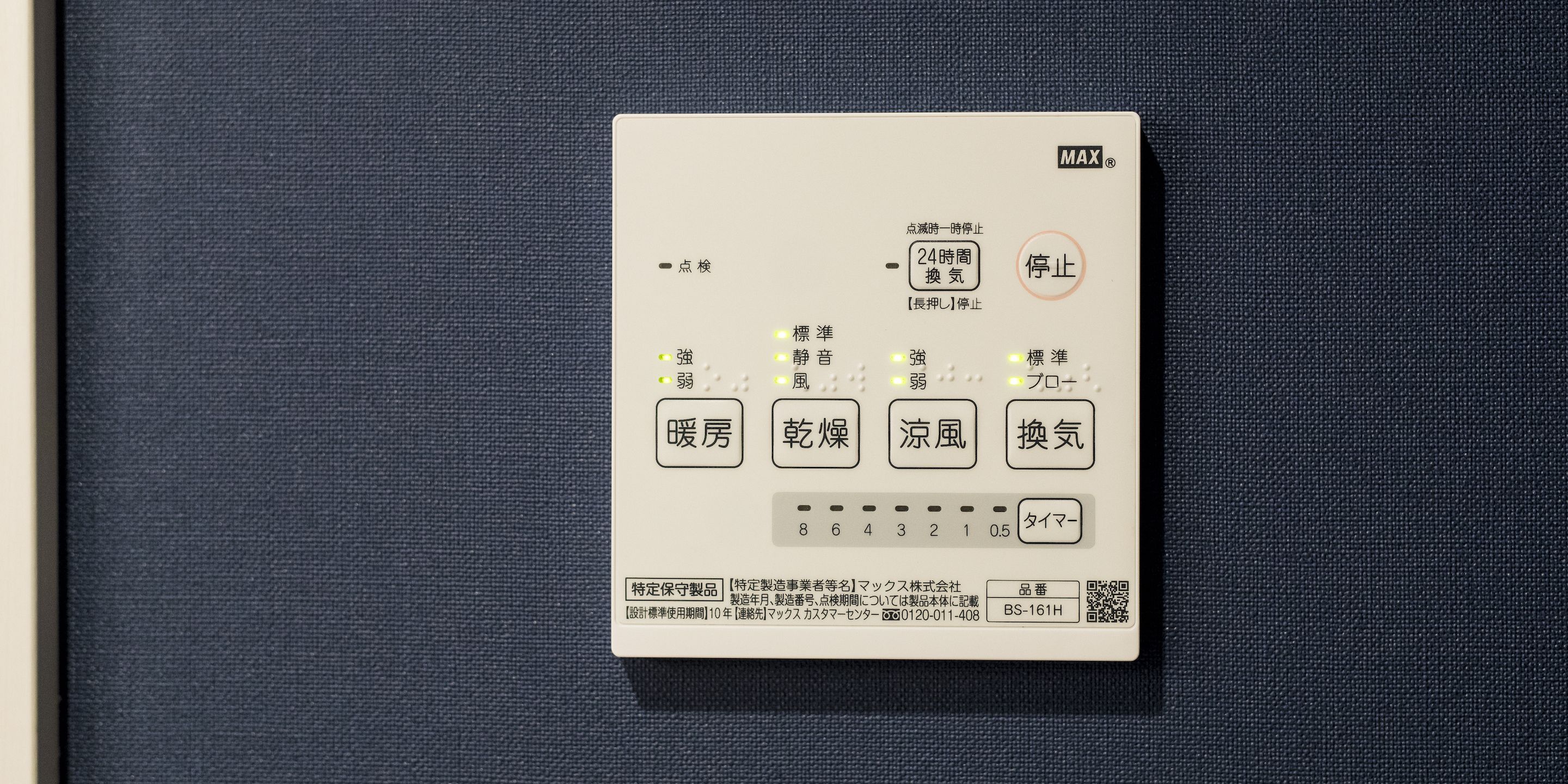 Un panel de control con texto y símbolos japoneses, que incluye botones para la temperatura y un temporizador.