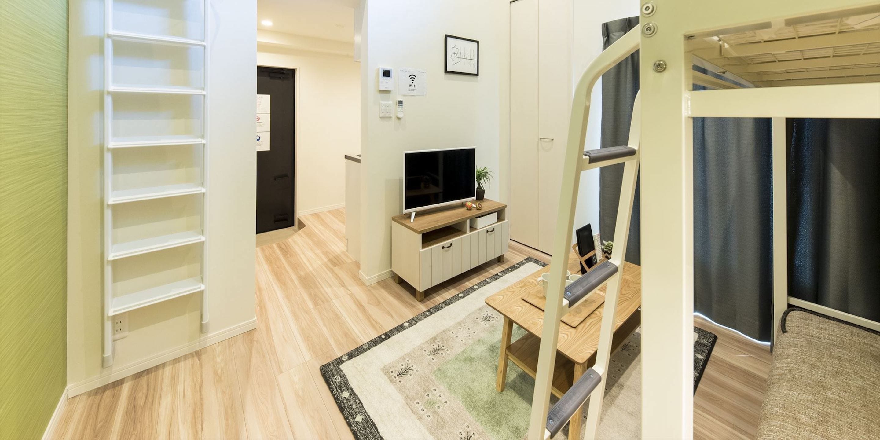 A modern living room with a TV, wooden furniture, a small table, and a bookshelf.