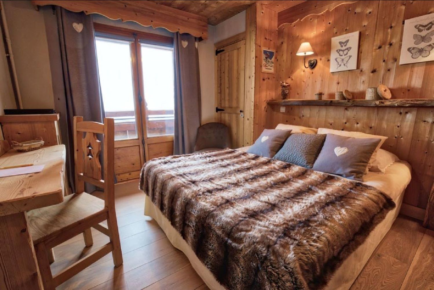 Una habitación de cabaña de madera con una cama, un escritorio y una silla.