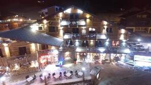 A multi-story wooden building with balconies, outdoor seating, and a restaurant. - Chalet Hôtel du Mont Charvin (Cohennoz)