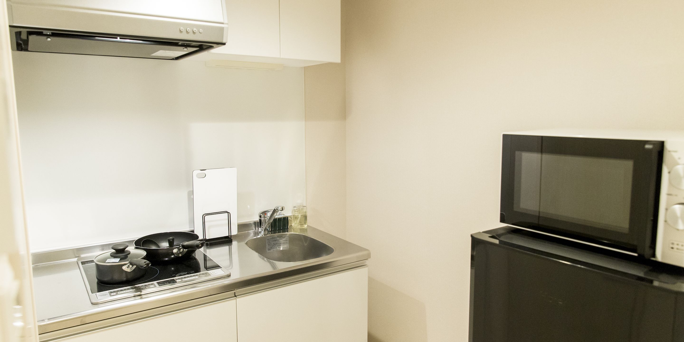 A compact kitchen with a stove, sink, and microwave.
