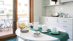 Una cocina con una mesa de comedor lista para el desayuno, un microondas y vistas al exterior.