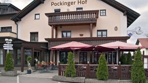 A building named 'Pockinger Hof' with outdoor seating and potted plants. - Hotel Gasthof Pockinger Hof (Pocking)