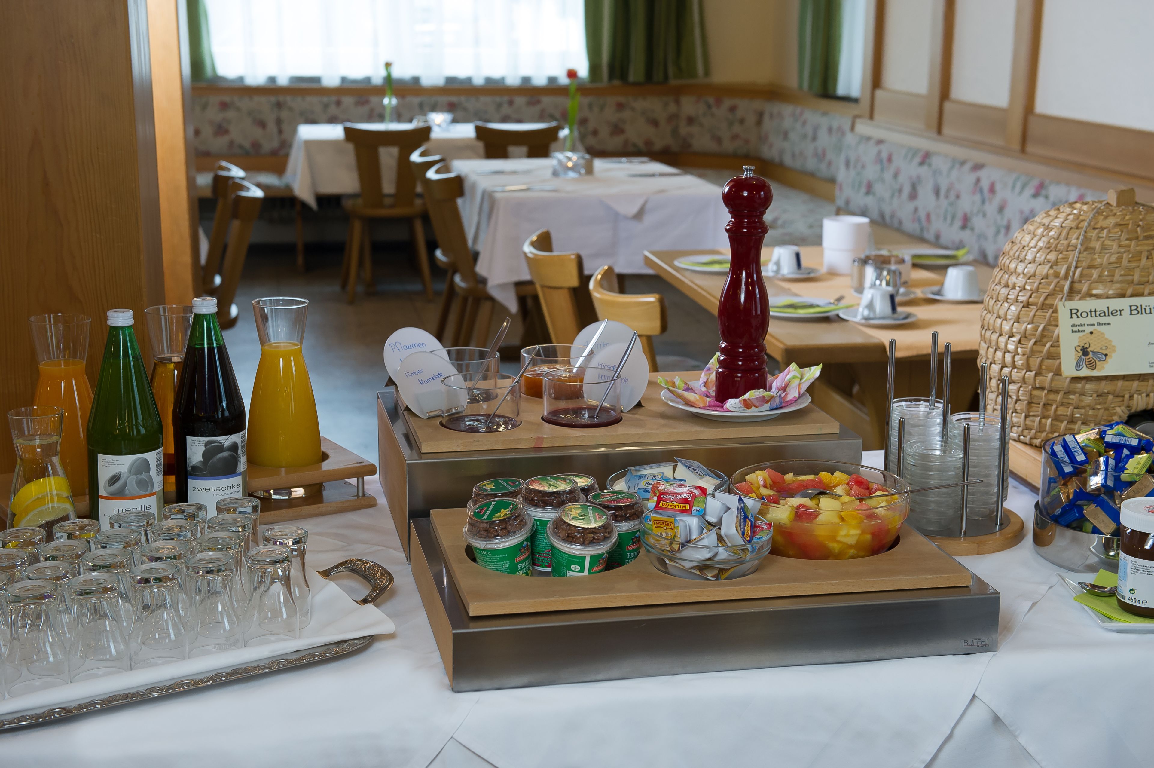 A breakfast buffet with various food items, condiments, and beverages.