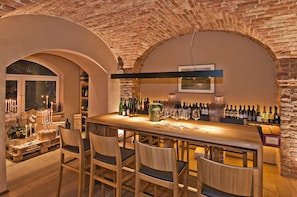 A bar area with wooden chairs, a wine rack, and a brick ceiling. - Hotel Gasthof Pockinger Hof (Pocking)