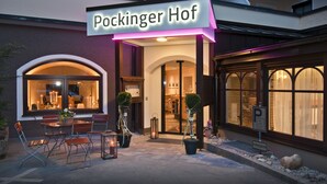 The exterior of Pockinger Hof hotel with a sign, outdoor seating area, and entrance. - Hotel Gasthof Pockinger Hof (Pocking)