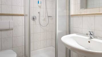 A bathroom with a shower, toilet, and sink.