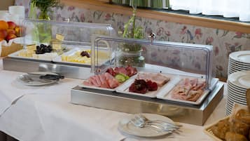 A buffet with various food items, including cheeses, meats, and fruits, displayed in clear containers.