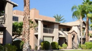 A multi-story building with a beige facade, a balcony on the second floor, and a staircase leading to the third floor. - With snowbirds landing here you will be at home. City of Scottsdale: 2027801. (Scottsdale)