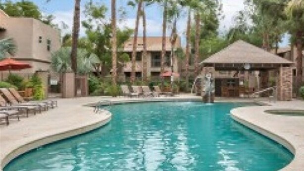 A swimming pool with lounge chairs and palm trees. - With snowbirds landing here you will be at home. City of Scottsdale: 2027801. (Scottsdale)