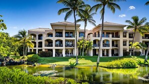 A resort with a pool, palm trees, and a well-maintained garden. - 🏖️Ground Floor Condo | Lagoon Views + Large Lanai + A/C (Waikoloa)