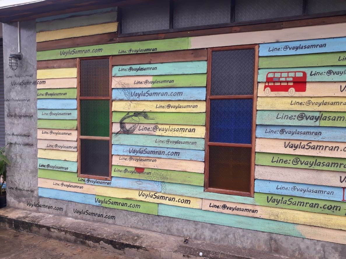 Una pared colorida con varias ventanas y datos de contacto para VaylaSamran.com y @vaylasamran.