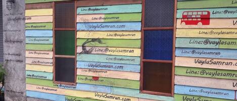 Una pared colorida con varias ventanas y datos de contacto para VaylaSamran.com y @vaylasamran.
