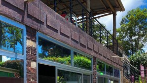 A building with large windows, a staircase, and a covered area with railings. - Royal Lake View Gardens (Kampala)