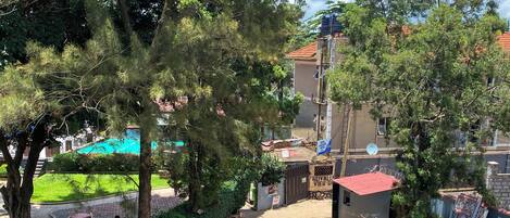 Ein Balkon mit Blick auf einen Innenhof, ein Gebäude mit rotem Dach und ein Schild mit der Aufschrift 'ROYAL VIEW'.