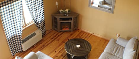 A cozy living room with a fireplace, a sofa, and a television.