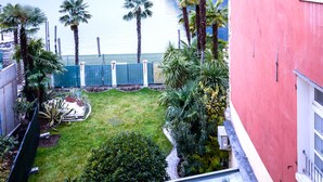 A red building with a small garden and a view of the sea. - Queen of the Lake (Riva del Garda)
