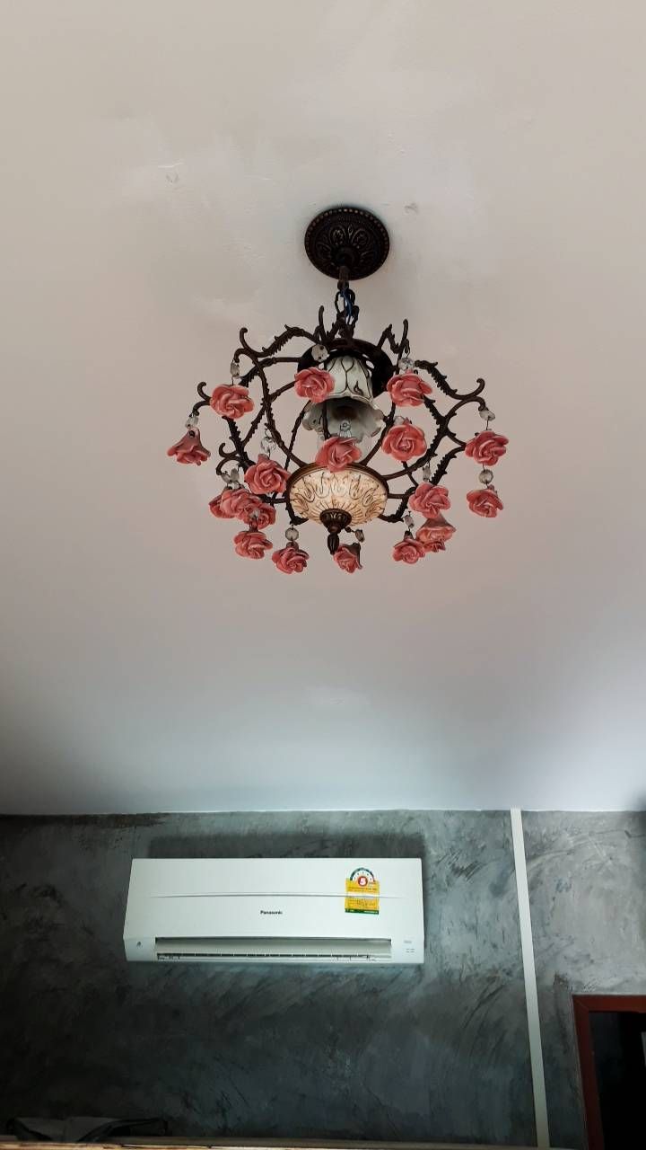 Techo decorado con una lámpara de araña y una unidad de aire acondicionado.
