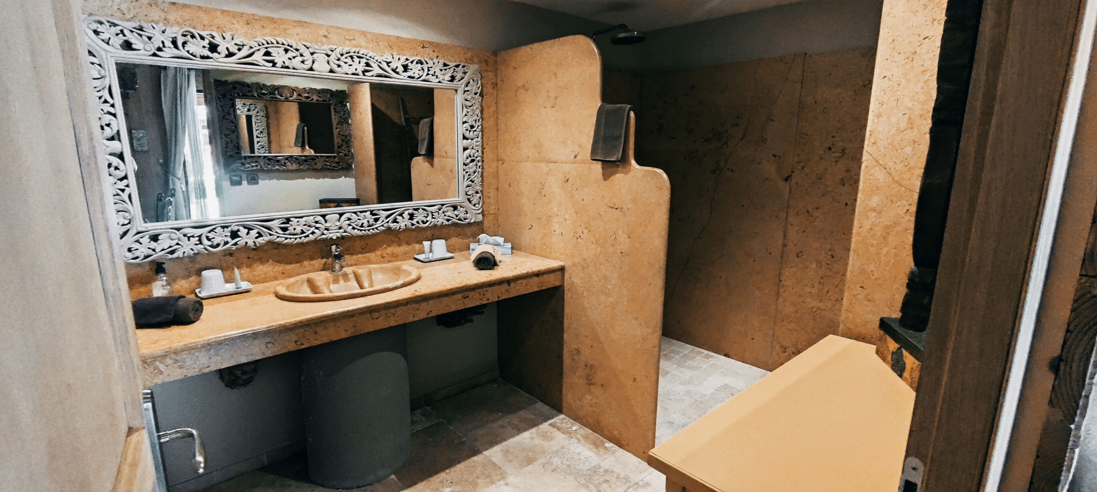 Un baño con lavamanos, espejo y zona de ducha.