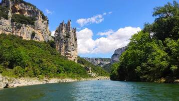 Une rivière bordée de falaises rocheuses et d’une végétation luxuriante de part et d’autre.