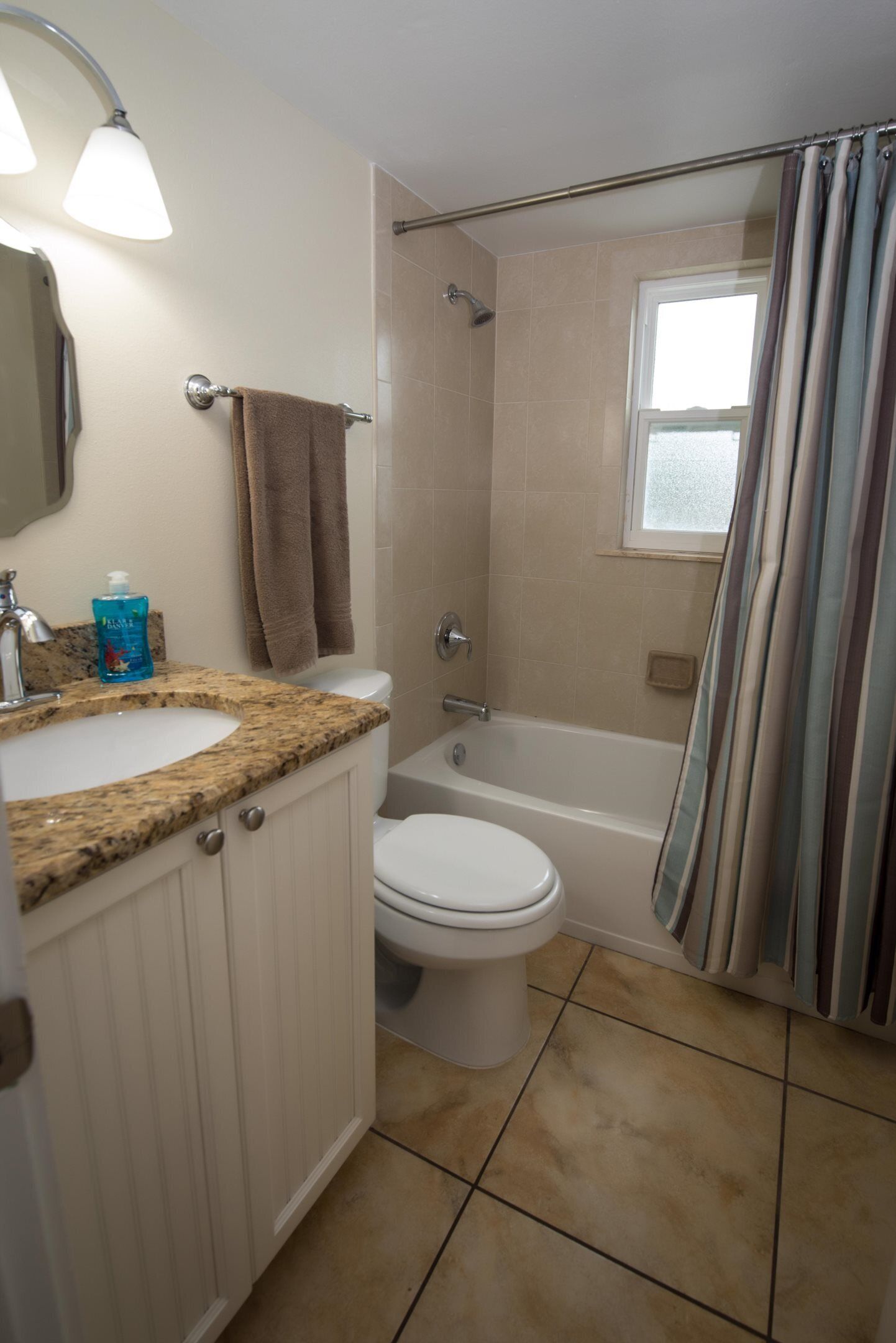 Un baño con lavamanos, inodoro y bañera.