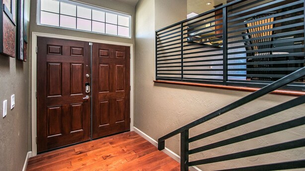 A hallway with a wooden floor, a double door, and a staircase with metal railings. - On golf course luxurious 2 bed/2 bath condo in the heart of Scottsdale (Scottsdale)