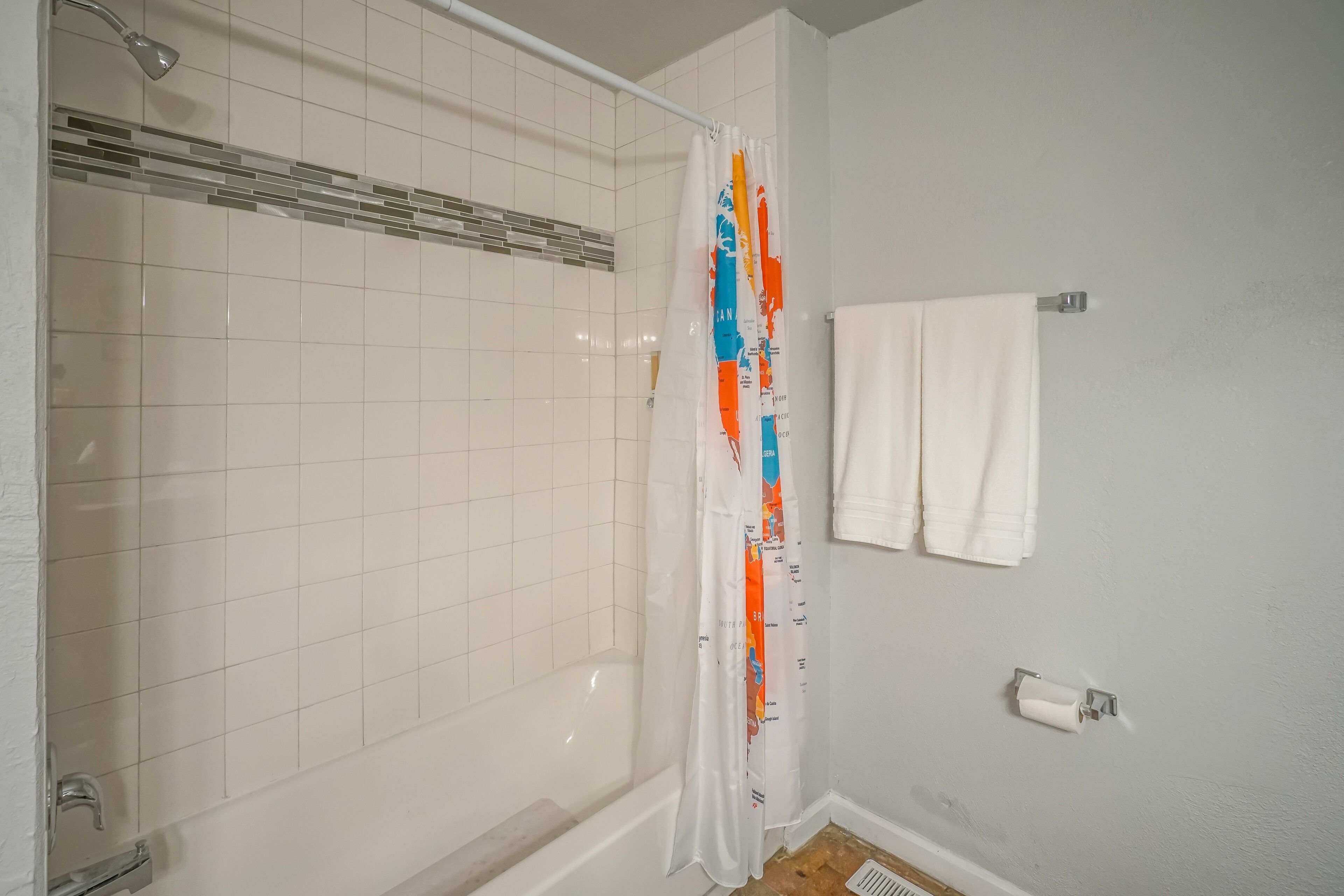 Une salle de bain avec une douche, des toilettes et un porte-serviettes.