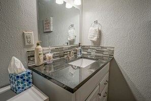 Een bad/douchecombinatie, een haardroger, handdoeken, zeep